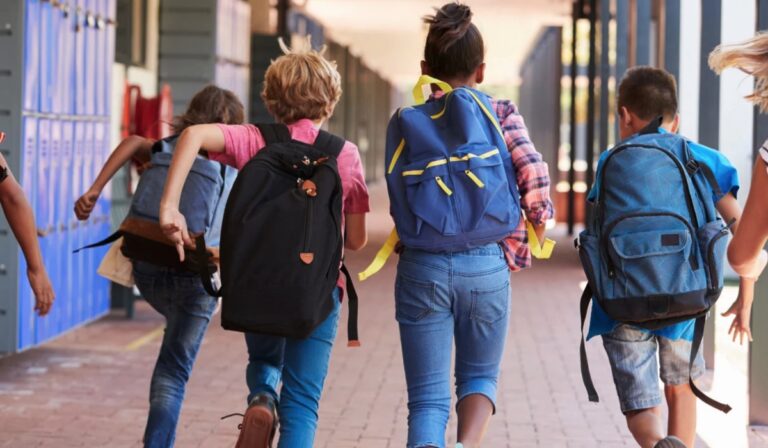 Niños y niñas corriendo en un colegio